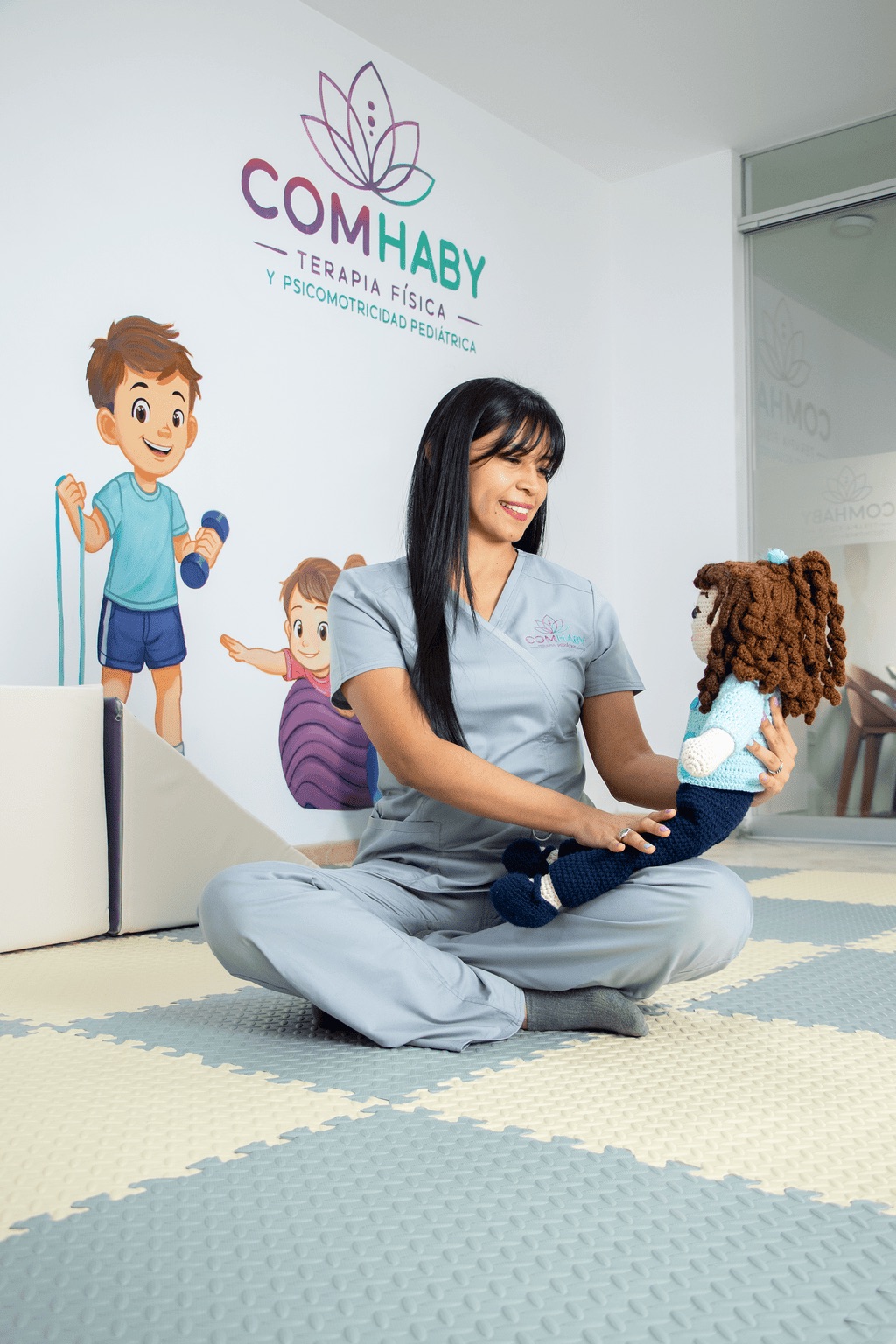 Terapeuta pediátrica interactuando con una muñeca durante una actividad de psicomotricidad